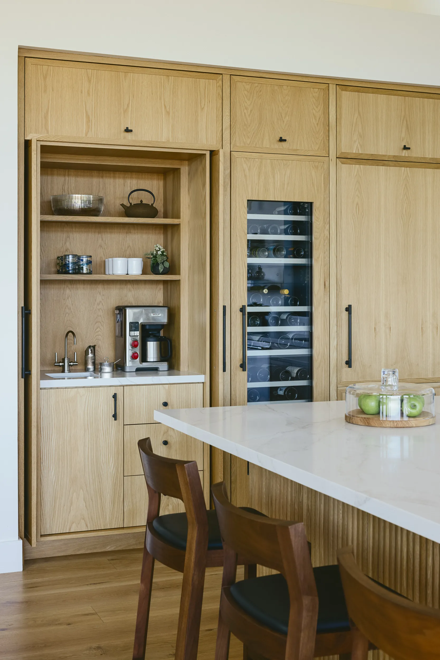 Custom oak kitchen pantry with integrated wine storage, coffee station, and white quartz countertop breakfast bar House Rupert interior design Santa Barbara and Montecito